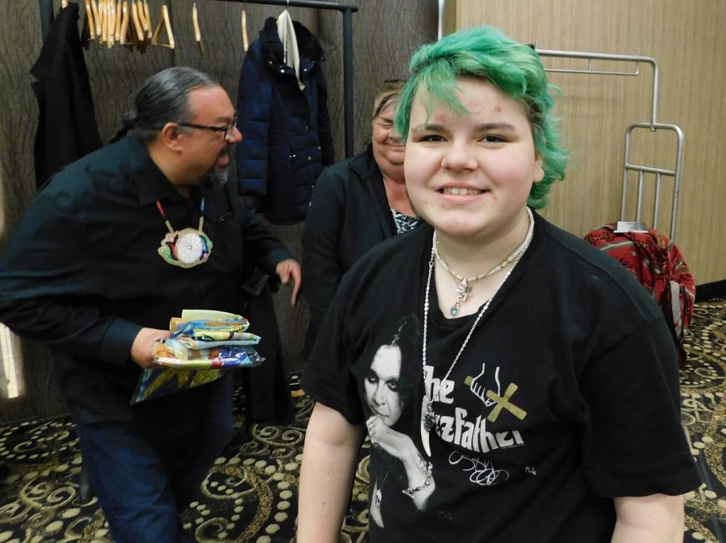 person smiling with two others laughing in background