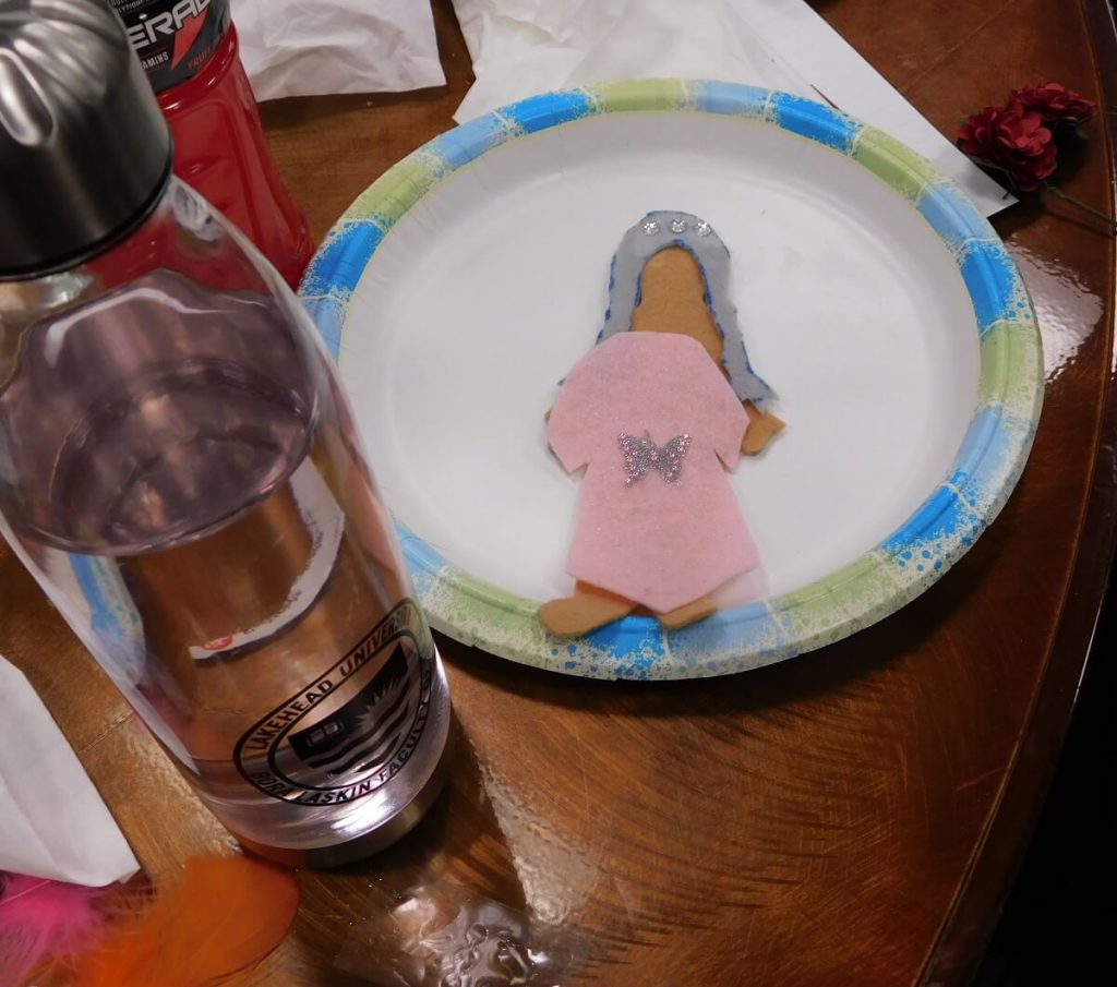 Felt doll on plate with a light pink dress