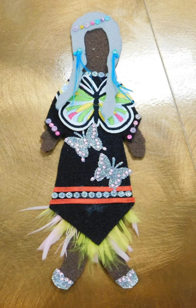 felt doll with black dress, butterfly stickers, and white hair