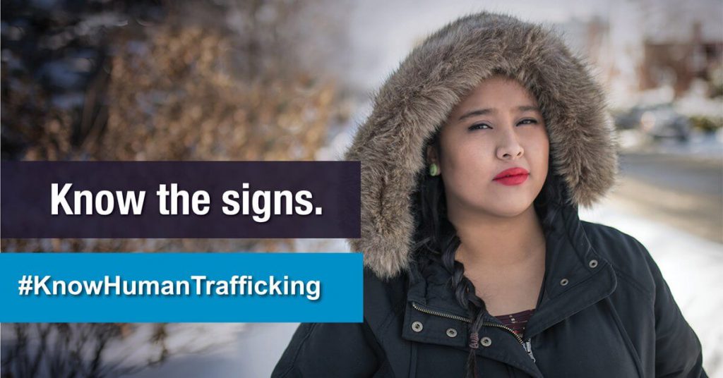 "Know the signs. #KnowHumanTrafficking" woman wearing fur jacket with hood up